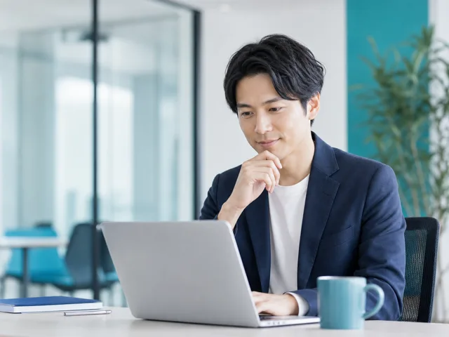 SaaS企業の担当者がノートPCで営業デモを確認する様子